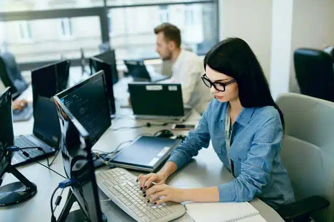 Young Woman Working And Programming On Computer In Office